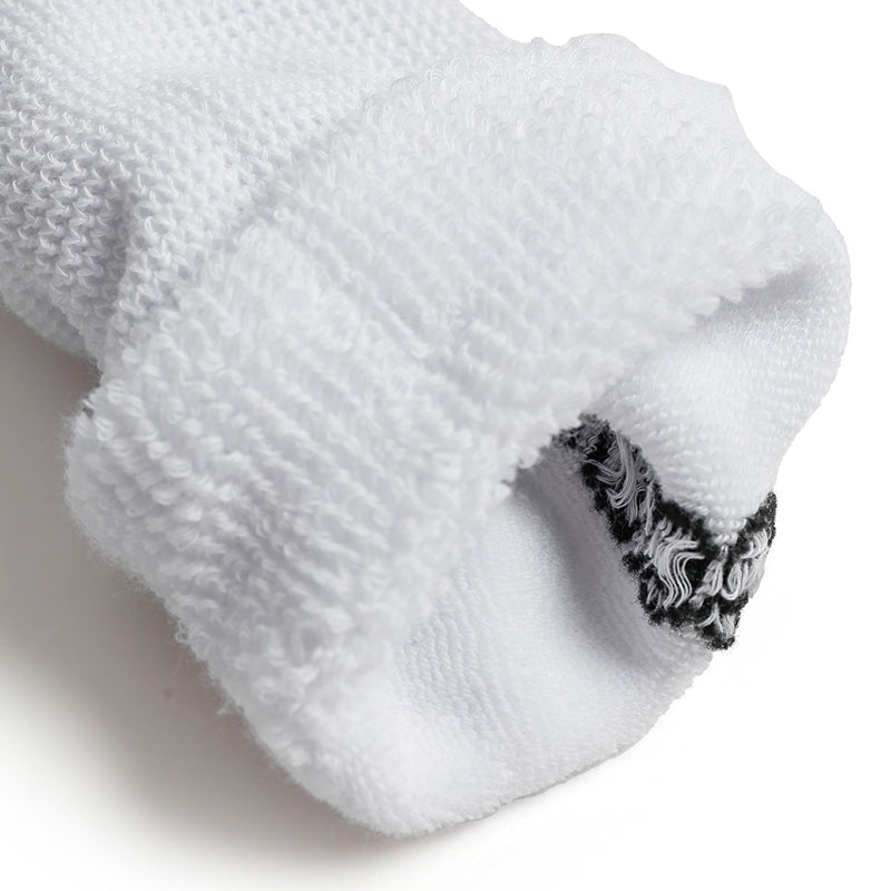 Close-up of a white sock with black patterned heel on a light background