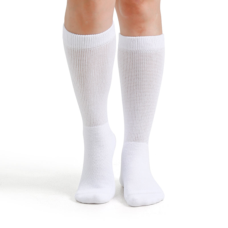 White knee-high socks worn by a person on a white background